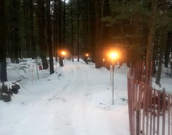 The  groomed & torch lit snowmobile trail from Gunnison Lake to Balthazars' Ice Shack.